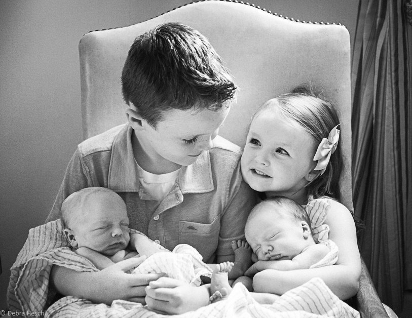 Brother & sister holding twin brothers