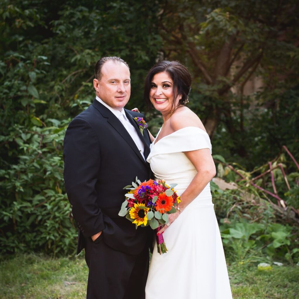 Bride and groom smiling together in an off-shoulder wedding gown and black tuxedo at their Cutillo's Restaurant wedding in Sanatoga PA
