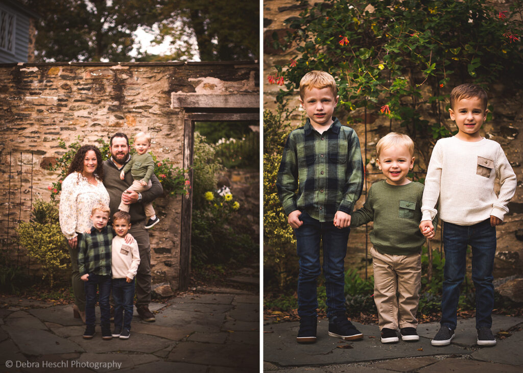 Family of five with three young sons standing in front of a stone wall at Harriton House during a fall family photography session.