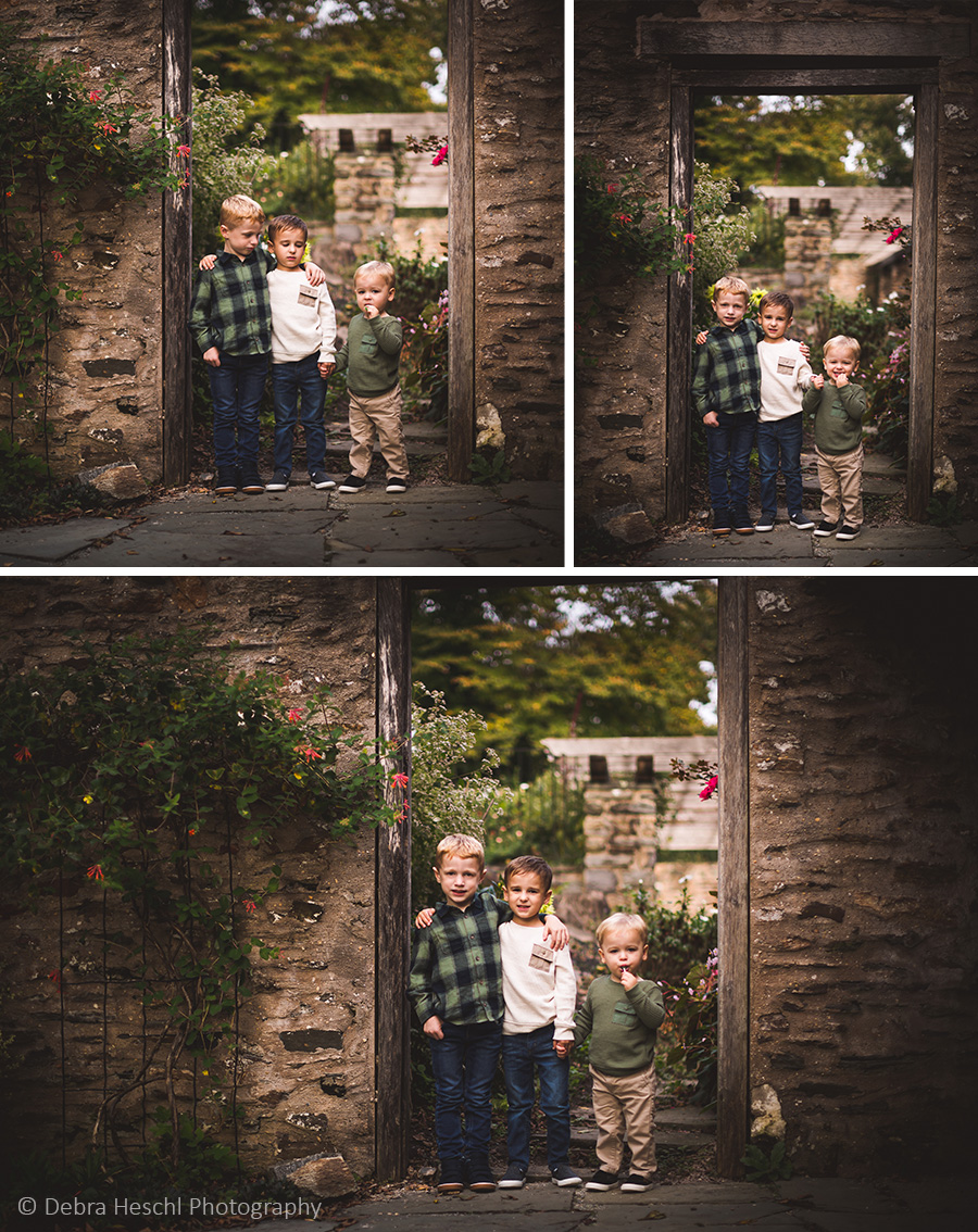 Three brothers standing together in a rustic stone doorway at Harriton House, Bryn Mawr PA family photographer.