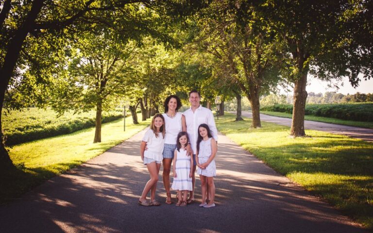 A family of five posing for a photo taken by Debra Heschl Photography at Norristown Farm Park in Norristown, Pa on a beautiful sunny clear day!