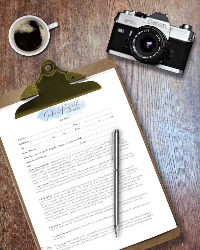 A wooden table holds a clipboard with a photography contract, pen, cup of black coffee, and a vintage camera. The scene conveys a creative, professional vibe.