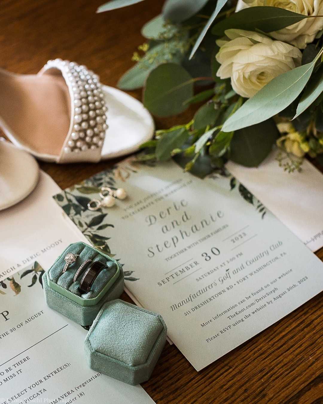 Wedding invitation, shoes, bouquet & wedding rings flatlay.