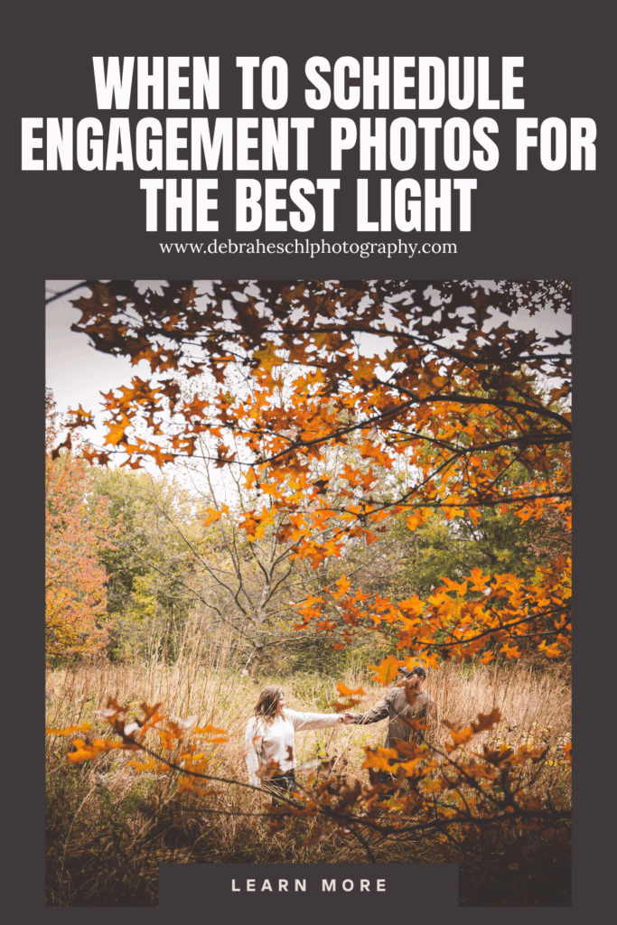 A couple holds hands in a grassy field framed by orange autumn leaves. The image promotes scheduling engagement photos for optimal lighting.