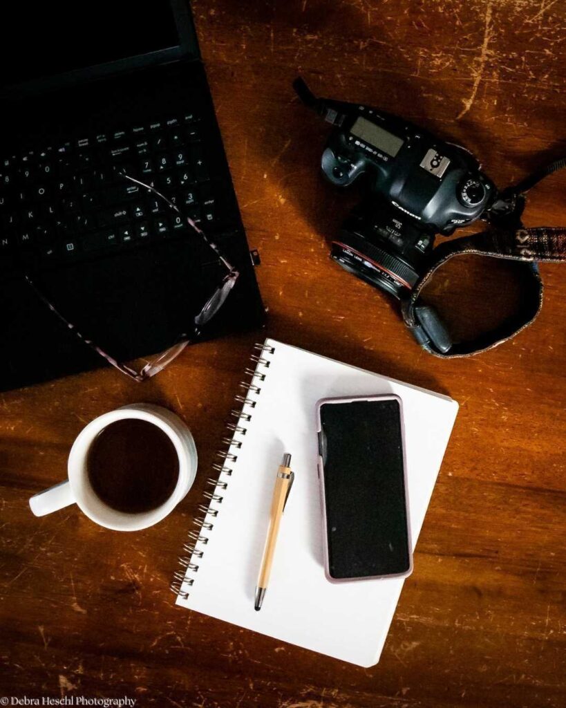 Planning the post-session workflow: coffee, notebook, and camera flat lay representing what to expect after your photo session.