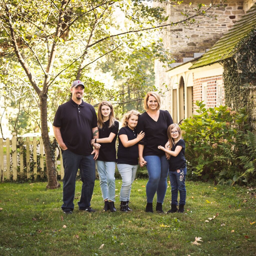 The Brown family posing together during an outdoor family photography session at Manor House of Prophecy Creek in Blue Bell, Pennsylvania.