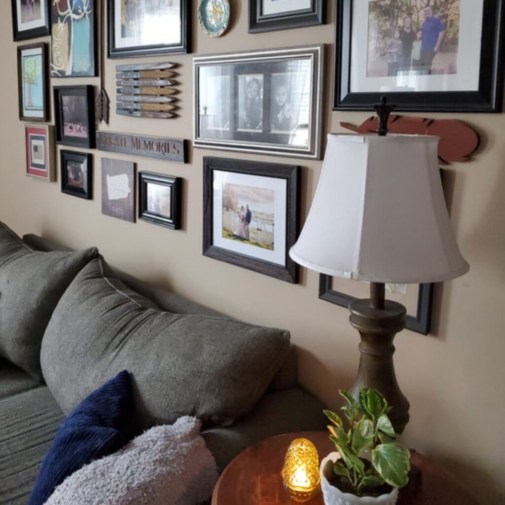 How to design a beautiful gallery wall with mixed frames above a cozy living room sofa.